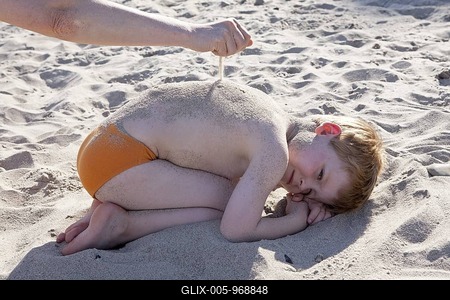 Hand sprinkling sand onto young boy on the beach, Kuehlungsborn, Mecklenburg-Western Pomerania, Germany, Europe-stock-foto
