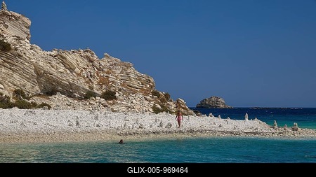 Rocks and a pebble beach meet turquoise waters under a clear sky, White Cliffs, White Beach, Makri Aspronisi Island, Natura 2000 area, boat trip, Aspronisi, Lipsi, Dodecanese, Greek Islands, Greece-stock-foto