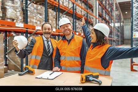 Warehouse workers and their manager are celebrating a successful logistics operation, expressing joy and teamwork in a modern storage facility-stock-foto