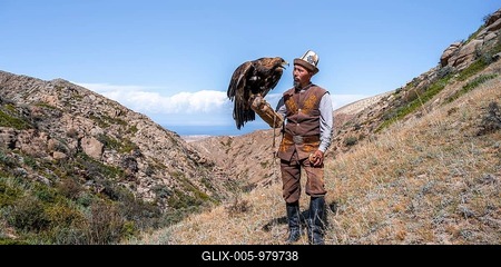 Traditional Kyrgyz eagle hunter with eagle in the mountains, hunting, near Bokonbayevo, Issyk Kul region, Kyrgyzstan-stock-foto