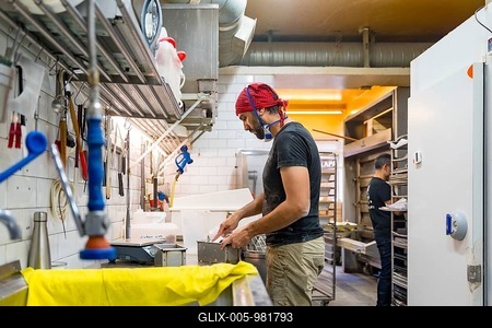 Male baker of bakery in the workshop of artisan bakery preparing the sourdoughs-stock-foto