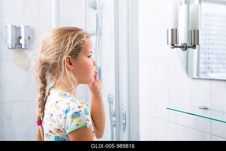 Little girl brushing her teeth in the bathroom-stock-foto