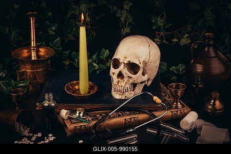 A skull with a candle on antique books, framed by medical tools in a dark atmosphere-stock-foto
