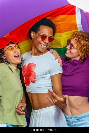 Studio portrait with purple background of a gay man and two lesbian women dancing covered by lgbt rainbow flag-stock-foto