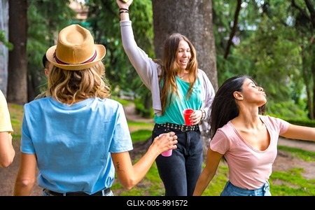 Multiethnic group of birthday party in the city park having fun and dancing with colored cups-stock-foto