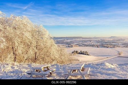 Rest area with benches and tables at a beautiful view on a hill in a frosty and snowy winter in the countryside, Ålleberg, Falköping, Sweden-stock-foto