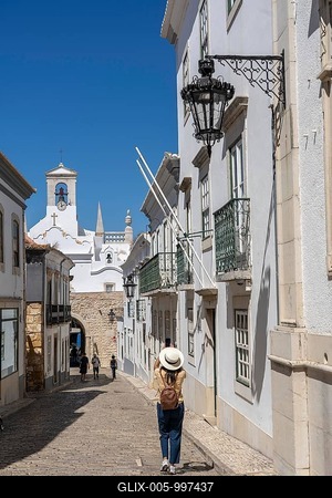Faro, old town centre alley, R. do Municipio, view of the Arco da Vila city gate, Algarve, Portugal-stock-foto