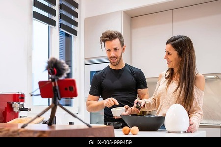 Couple food vlogger making video while prepping vegetables in kitchen-stock-foto