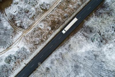 Truck on road with snowy forest in Hungary-stock-photo