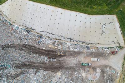 Garbage trucks unload garbage to a landfill, drone photo-stock-photo