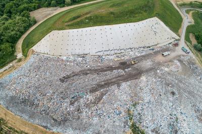 Garbage trucks unload garbage to a landfill, drone photo-stock-photo