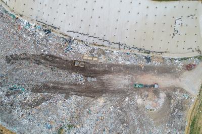 Garbage trucks unload garbage to a landfill, drone photo-stock-photo