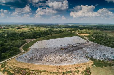 Garbage trucks unload garbage to a landfill, drone photo-stock-photo