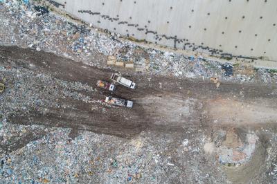 Garbage trucks unload garbage to a landfill, drone photo-stock-photo