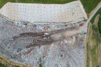 Garbage trucks unload garbage to a landfill, drone photo-stock-photo