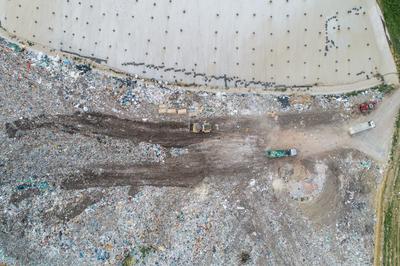 Garbage trucks unload garbage to a landfill, drone photo-stock-photo