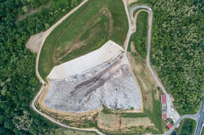 Garbage trucks unload garbage to a landfill, drone photo-stock-photo