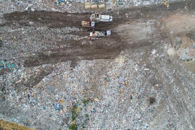 Garbage trucks unload garbage to a landfill, drone photo-stock-photo