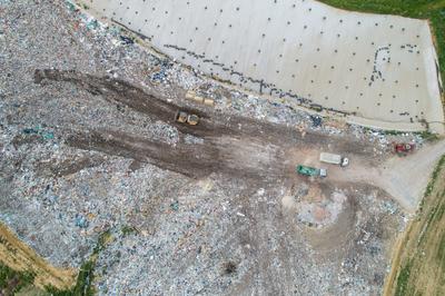 Garbage trucks unload garbage to a landfill, drone photo-stock-photo