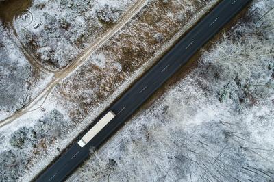 Truck on road with snowy forest in Hungary-stock-photo