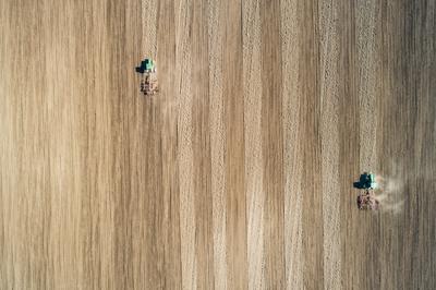 Aerial view of tractor plowing farm field in preparation for spring planting-stock-foto