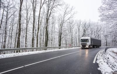 snowy road at cold wintertime with fast truck-stock-foto