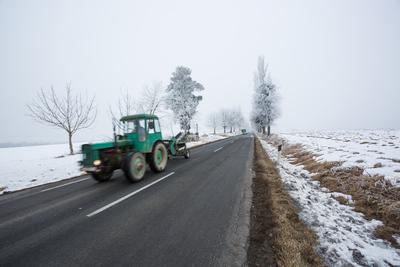 Fast moving tractor with snowy road-stock-foto