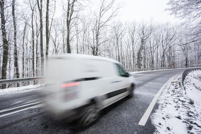 fast moving van with snowy road at cold wintertime-stock-photo