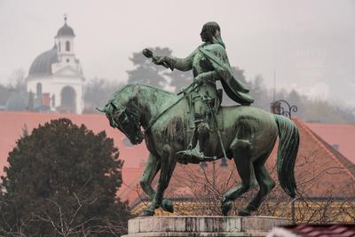 statue of Janos Hunyadi on Szechenyi Square in Pecs, Hungary with chapel at background-stock-foto