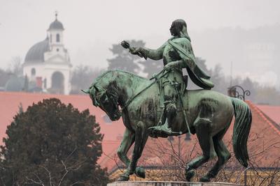 statue of Janos Hunyadi on Szechenyi Square in Pecs, Hungary with chapel at background-stock-foto