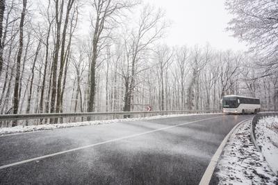 snowy road at cold wintertime with bus-stock-foto