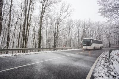 snowy road at cold wintertime with bus-stock-foto