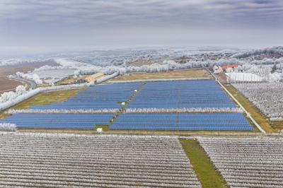 Winter frosty vineyard landscape covered by white flake with solar energy panels-stock-photo