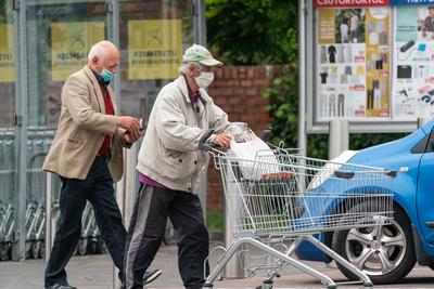 PECS - MAY 27 : Old man go to shopping on the street  on 27 May 2020 in Pecs, Hungary. During coronavirus pandemic, everybody have to waering face mask-stock-photo