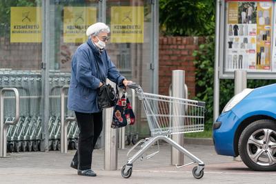 PECS - MAY 27 : Old woman go to shopping on the street  on 27 May 2020 in Pecs, Hungary. During coronavirus pandemic, everybody have to waering face mask-stock-photo