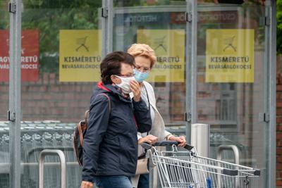 PECS - MAY 27 : Old woman go to shopping on the street  on 27 May 2020 in Pecs, Hungary. During coronavirus pandemic, everybody have to waering face mask-stock-photo