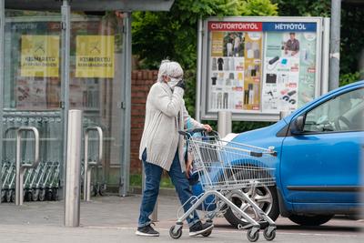 PECS - MAY 27 : Old woman go to shopping on the street  on 27 May 2020 in Pecs, Hungary. During coronavirus pandemic, everybody have to waering face mask-stock-photo