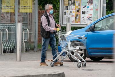 PECS - MAY 27 : Old man go to shopping on the street  on 27 May 2020 in Pecs, Hungary. During coronavirus pandemic, everybody have to waering face mask-stock-photo