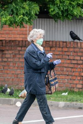 PECS - MAY 27 : Old woman go to shopping on the street  on 27 May 2020 in Pecs, Hungary. During coronavirus pandemic, everybody have to waering face mask-stock-photo