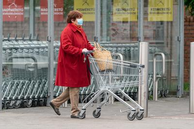 PECS - MAY 27 : Old woman go to shopping on the street  on 27 May 2020 in Pecs, Hungary. During coronavirus pandemic, everybody have to waering face mask-stock-photo