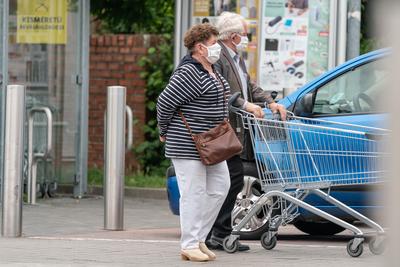 PECS - MAY 27 : Old woman go to shopping on the street  on 27 May 2020 in Pecs, Hungary. During coronavirus pandemic, everybody have to waering face mask-stock-photo