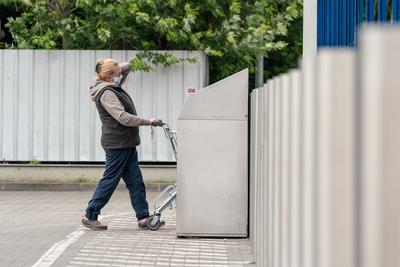 PECS - MAY 27 : Old woman go to shopping on the street  on 27 May 2020 in Pecs, Hungary. During coronavirus pandemic, everybody have to waering face mask-stock-photo