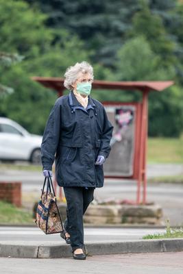 PECS - MAY 27 : Old woman go to shopping on the street  on 27 May 2020 in Pecs, Hungary. During coronavirus pandemic, everybody have to waering face mask-stock-photo