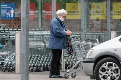 PECS - MAY 27 : Old woman go to shopping on the street  on 27 May 2020 in Pecs, Hungary. During coronavirus pandemic, everybody have to waering face mask-stock-photo