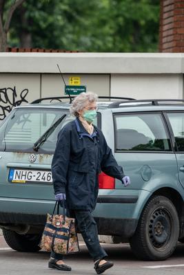 PECS - MAY 27 : Old woman go to shopping on the street  on 27 May 2020 in Pecs, Hungary. During coronavirus pandemic, everybody have to waering face mask-stock-photo