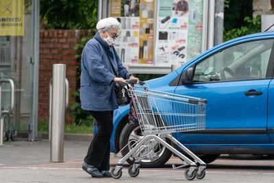 PECS - MAY 27 : Old woman go to shopping on the street  on 27 May 2020 in Pecs, Hungary. During coronavirus pandemic, everybody have to waering face mask-stock-photo