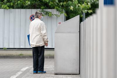 PECS - MAY 27 : Old woman go to shopping on the street  on 27 May 2020 in Pecs, Hungary. During coronavirus pandemic, everybody have to waering face mask-stock-photo