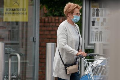 PECS - MAY 27 : Old woman go to shopping on the street  on 27 May 2020 in Pecs, Hungary. During coronavirus pandemic, everybody have to waering face mask-stock-photo