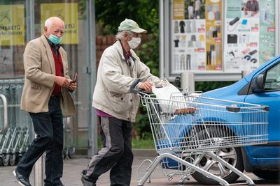 PECS - MAY 27 : Old man go to shopping on the street  on 27 May 2020 in Pecs, Hungary. During coronavirus pandemic, everybody have to waering face mask-stock-photo