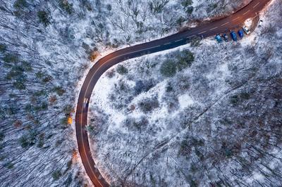 aerial view of curvy road with snowy forest-stock-foto